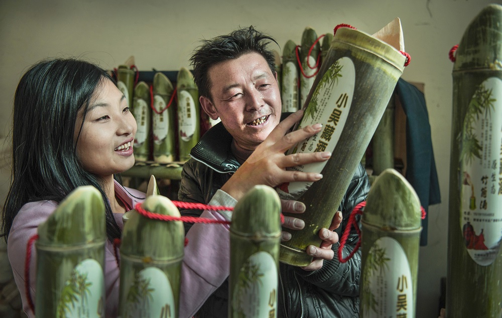 劉青青在村民吳孝兵的家，了解竹筒酒的生產過程。
